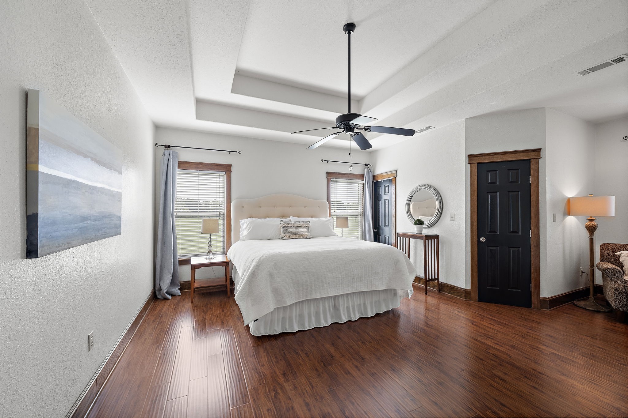 10411 County Road 65 Rosharon, TX 77583 - Photo 16 of 29 The primary bedroom is thoughtfully tucked away off the kitchen, offering a sense of retreat. It features a tray ceiling and spacious his and hers walk-in closets.