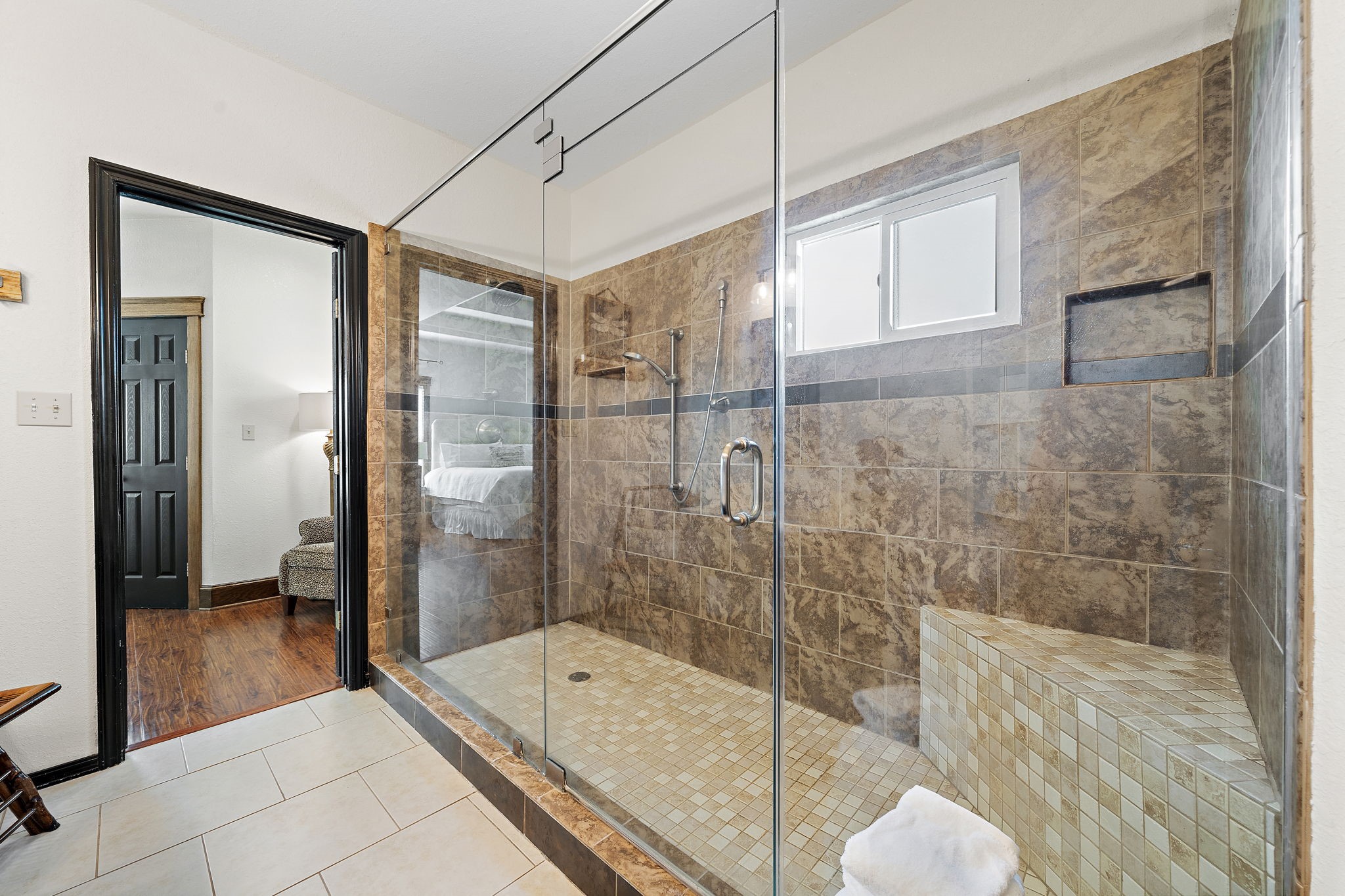 10411 County Road 65 Rosharon, TX 77583 - Photo 19 of 29 The walk-in shower features a built-in seat and dual shower heads, offering a refined and relaxing experience.