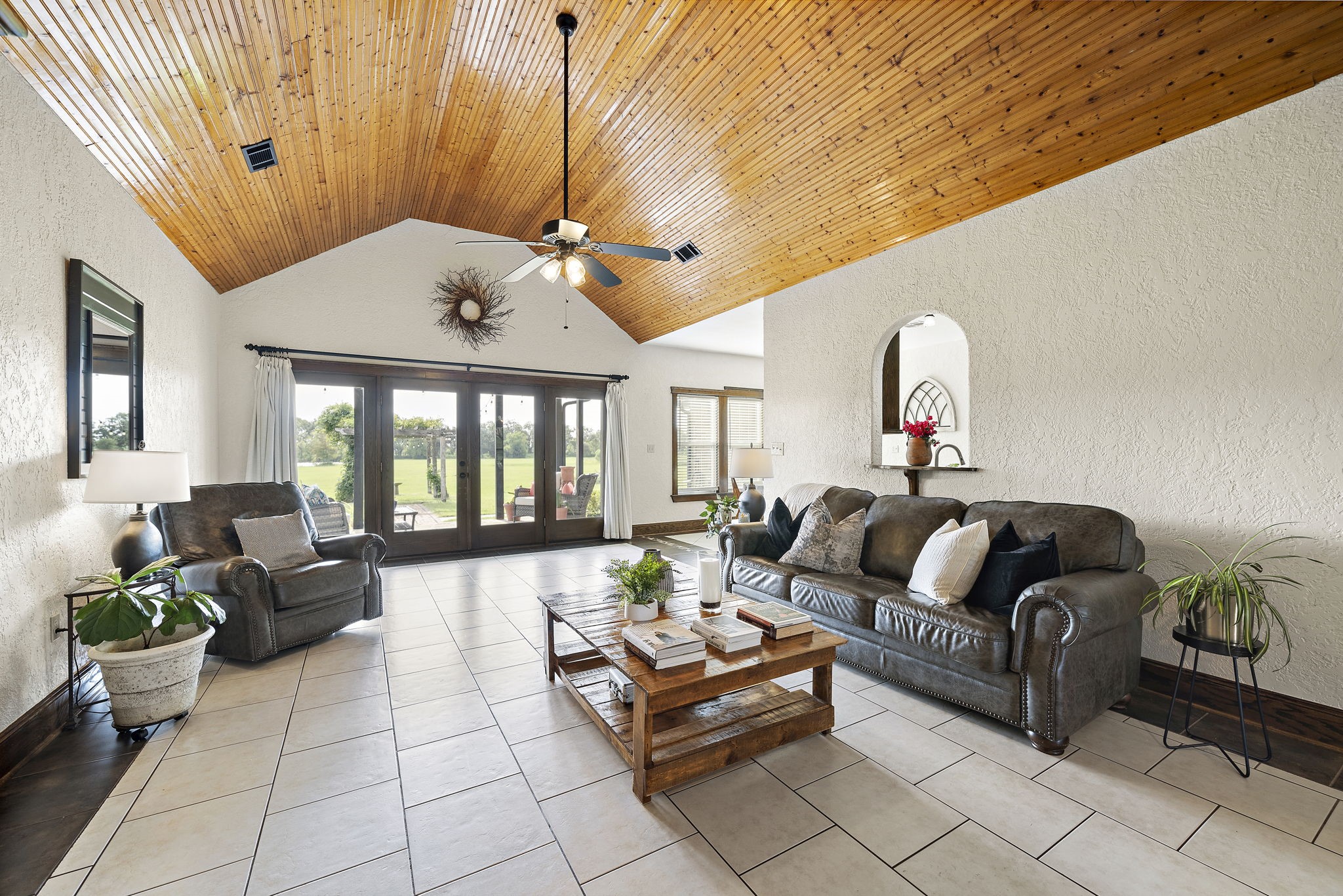 10411 County Road 65 Rosharon, TX 77583 - Photo 9 of 29 Living room is open and airy with vaulted ceilings and glass French doors that fill the space with natural light and create a welcoming atmosphere.