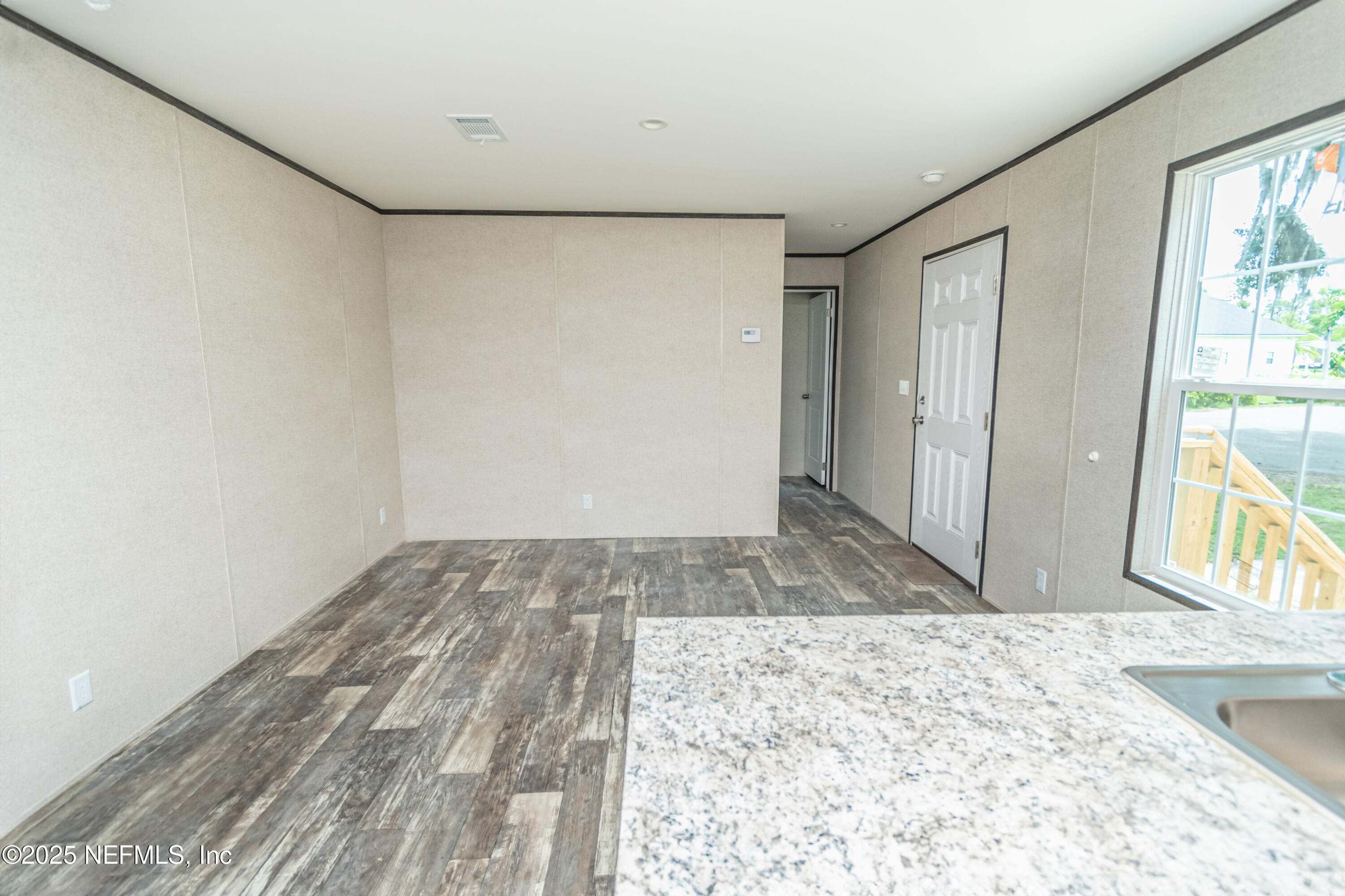 406 Sycamore Drive Macclenny, FL 32063 - Photo 8 of 22 a view of a big room with wooden floor and windows