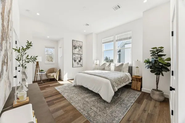 a bedroom with a large bed and a potted plant