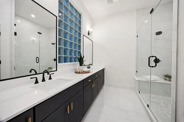 a bathroom with a double vanity sink a mirror and shower