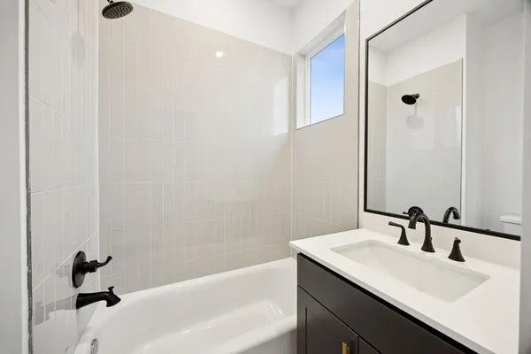 a bathroom with a tub sink vanity and a mirror