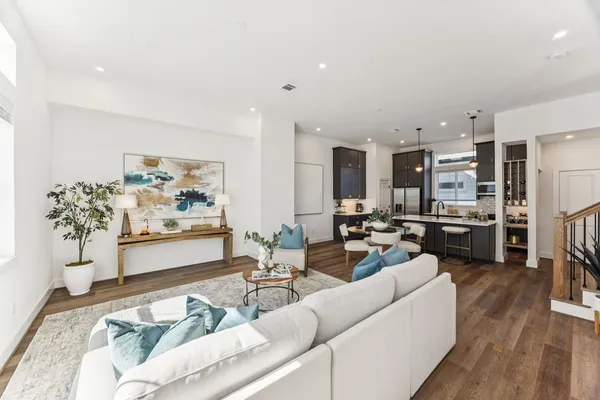 a living room with furniture kitchen view and a large window