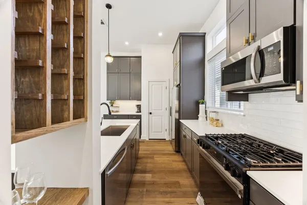 a kitchen with stainless steel appliances a stove a sink and a refrigerator