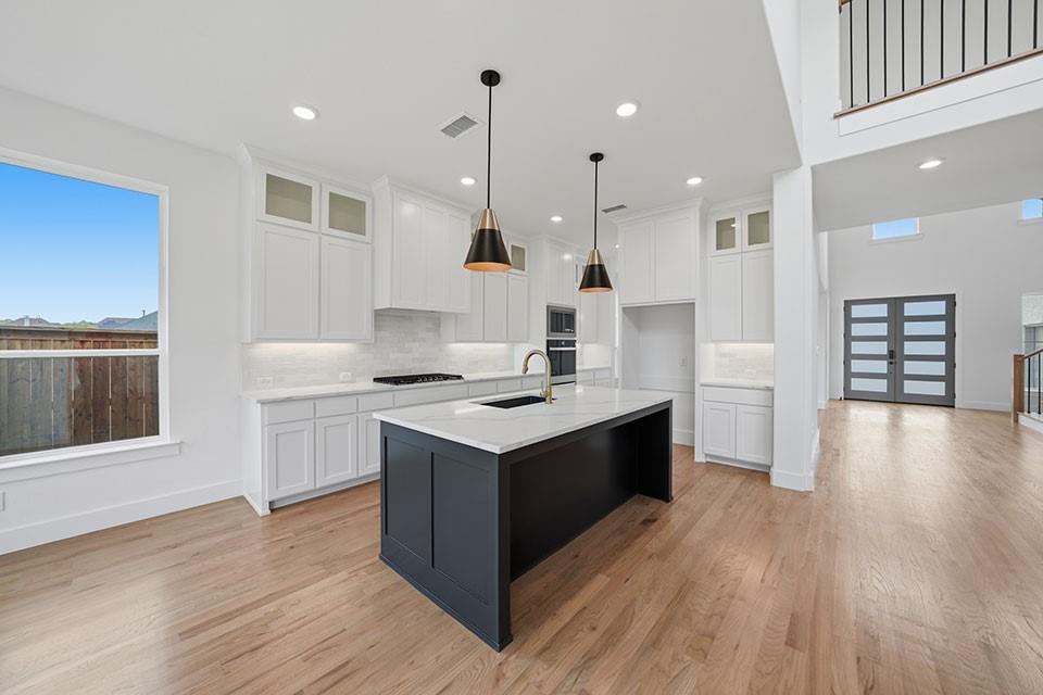 205 Ardsley Way Allen, TX 75013 - Photo 14 of 37 a kitchen with a sink stove and wooden floor