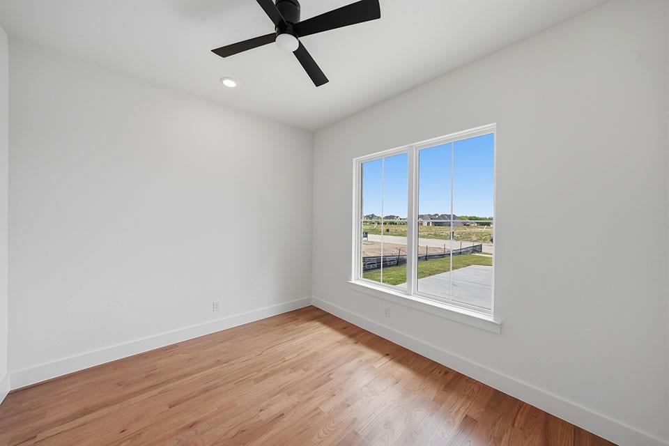 205 Ardsley Way Allen, TX 75013 - Photo 5 of 37 an empty room with wooden floor fan and windows
