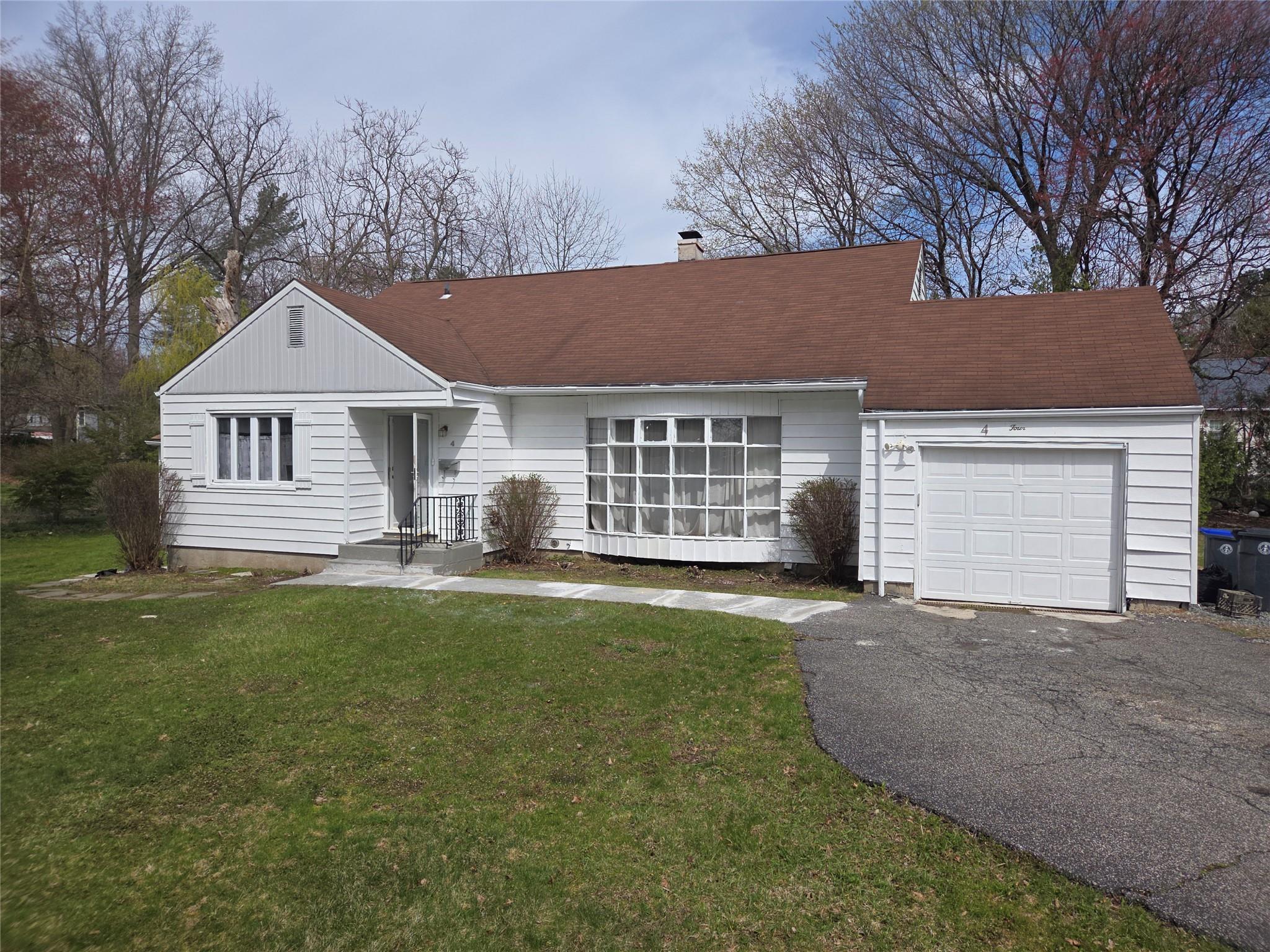 a front view of a house with a garden and yard