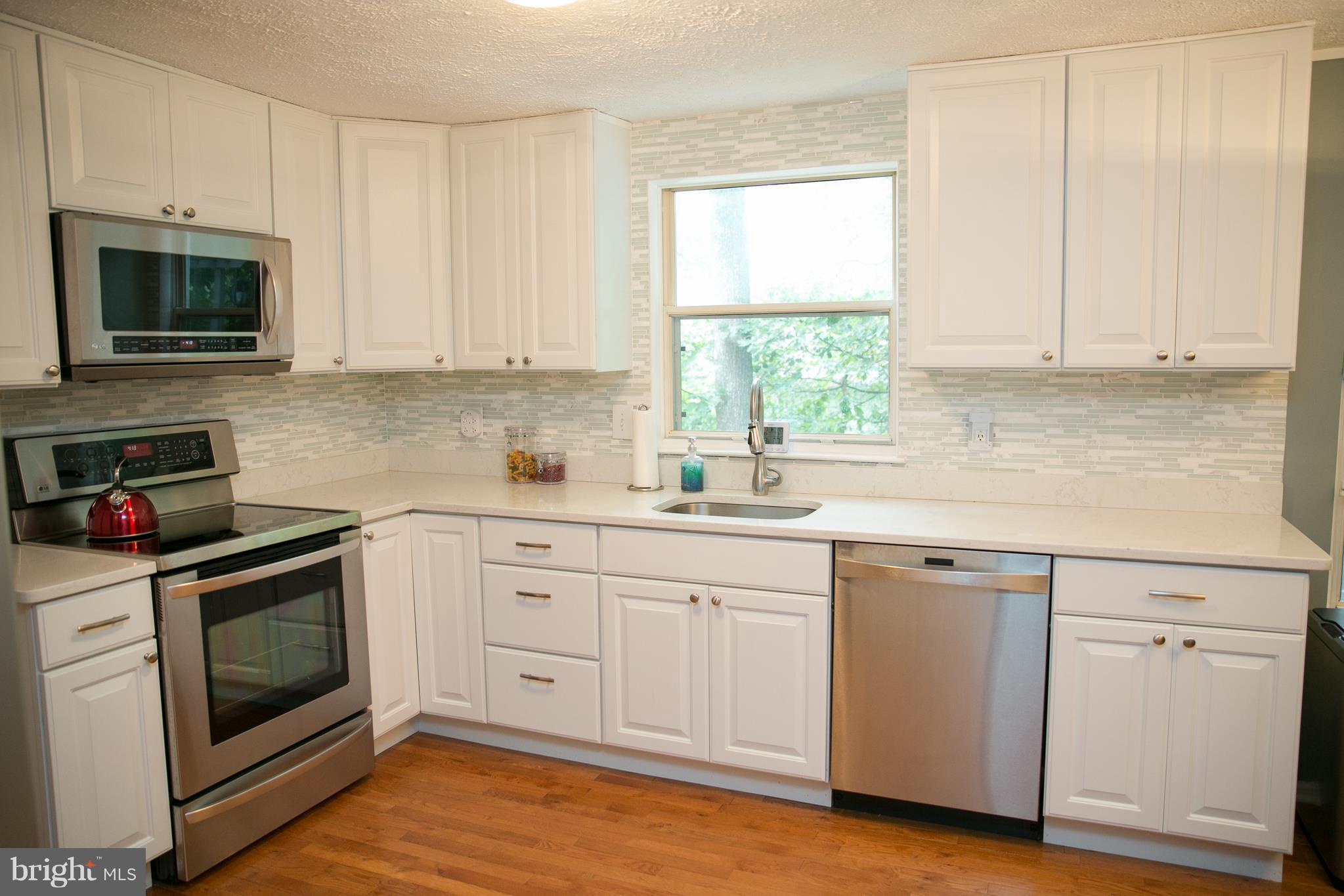 7835 Roundabout Way Springfield, VA 22153 - Photo 9 of 26 a kitchen with white cabinets stainless steel appliances and sink