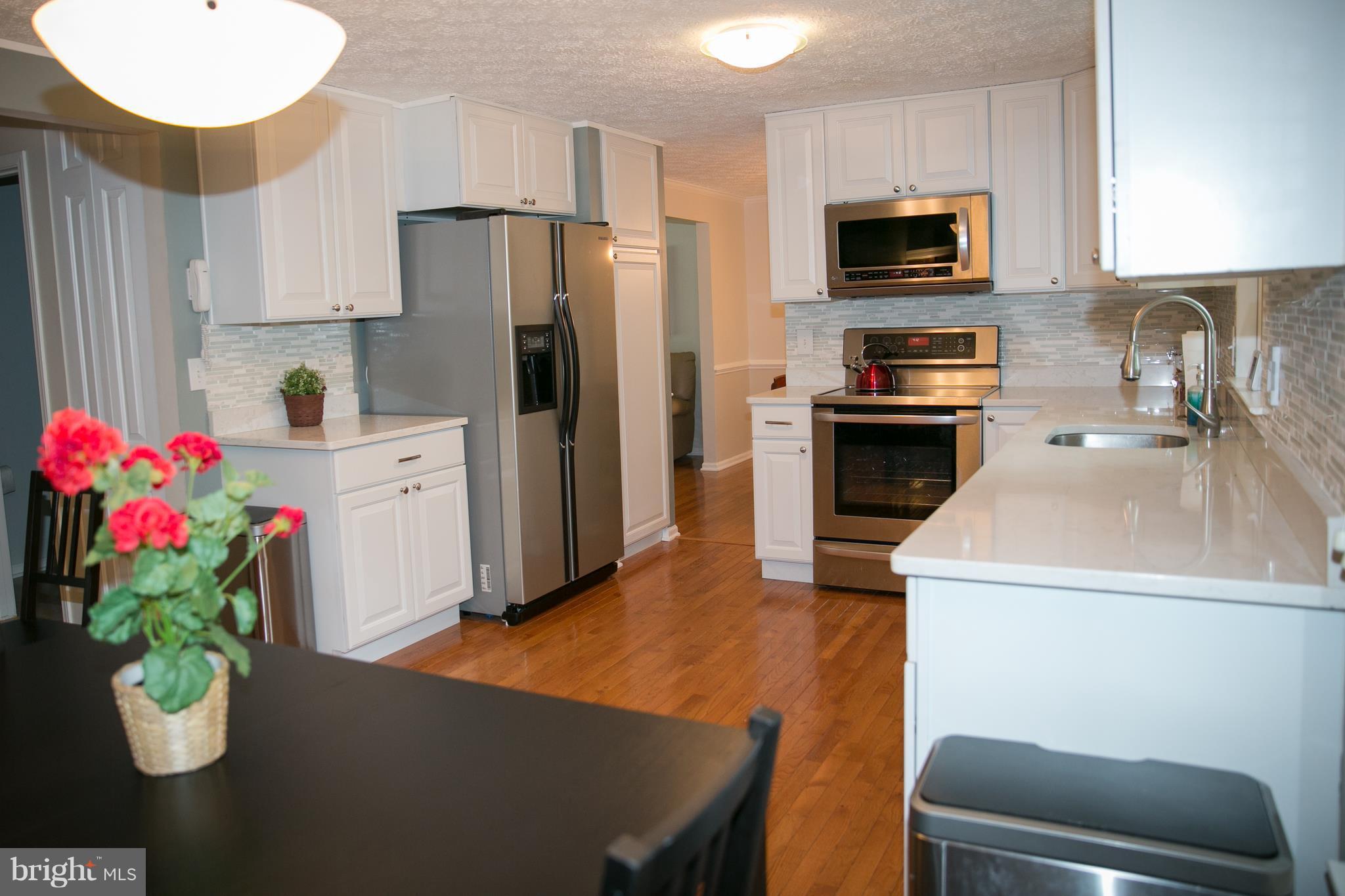 7835 Roundabout Way Springfield, VA 22153 - Photo 10 of 26 a kitchen with stainless steel appliances a refrigerator sink and stove