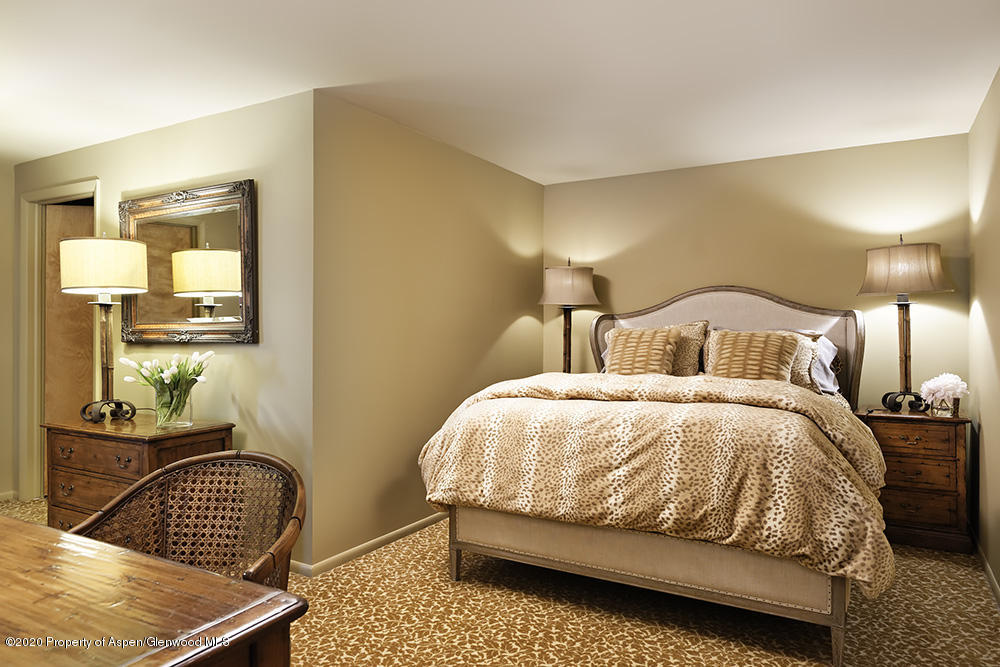 880 Buck Point Road Carbondale, CO 81623 - Photo 25 of 40 a bedroom with a bed and wooden floor