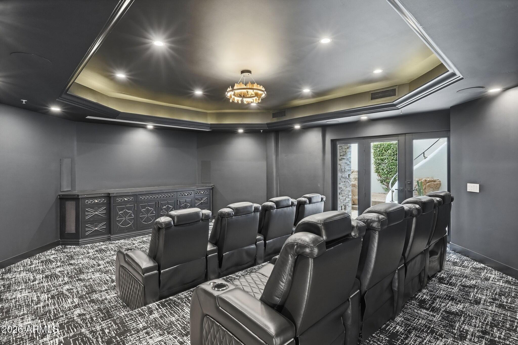 7475 East Gainey Ranch Road, Unit 7 Scottsdale, AZ 85258 - Photo 52 of 77 a media room with lots of chairs and a chandelier