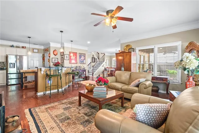a living room with furniture kitchen view and a large window