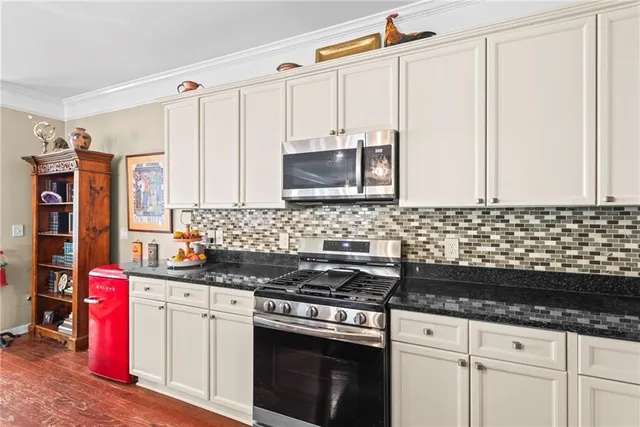 a kitchen with granite countertop a sink stove and cabinets