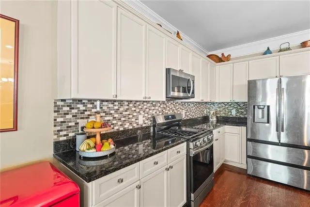 a kitchen with stainless steel appliances granite countertop a sink stove and refrigerator
