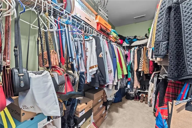 a view of walk in closet with clothes