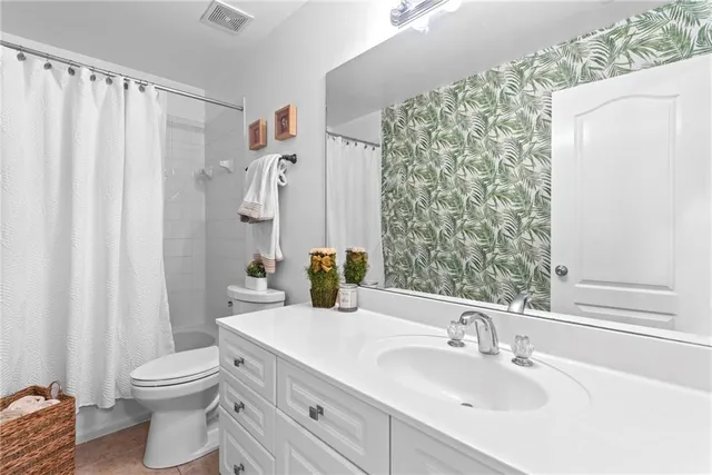 a bathroom with a sink a toilet and shower curtain