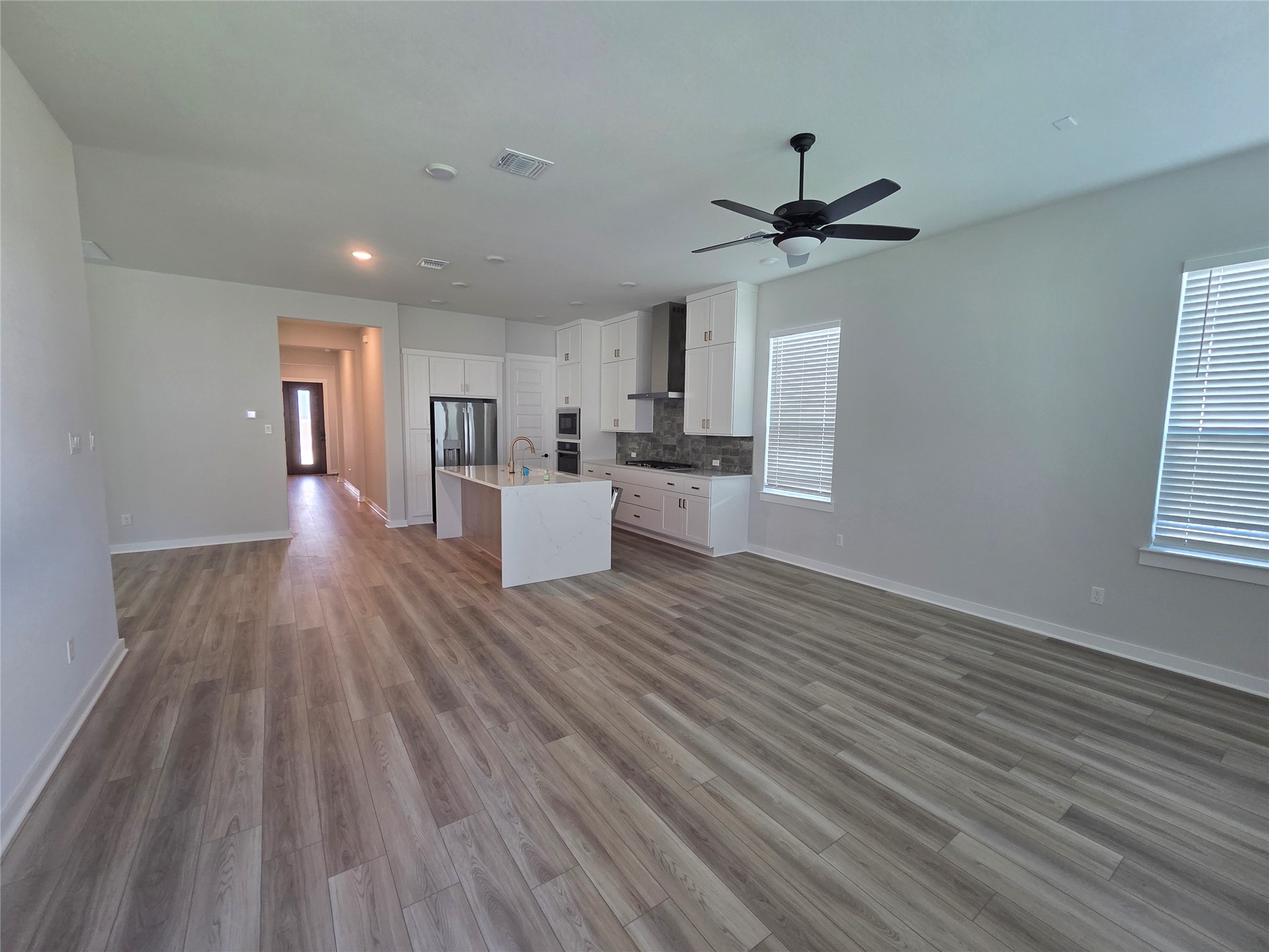 332 Marisol Bend Georgetown, TX 78626 - Photo 29 of 31 a view of a big room with wooden floor a ceiling fan and windows