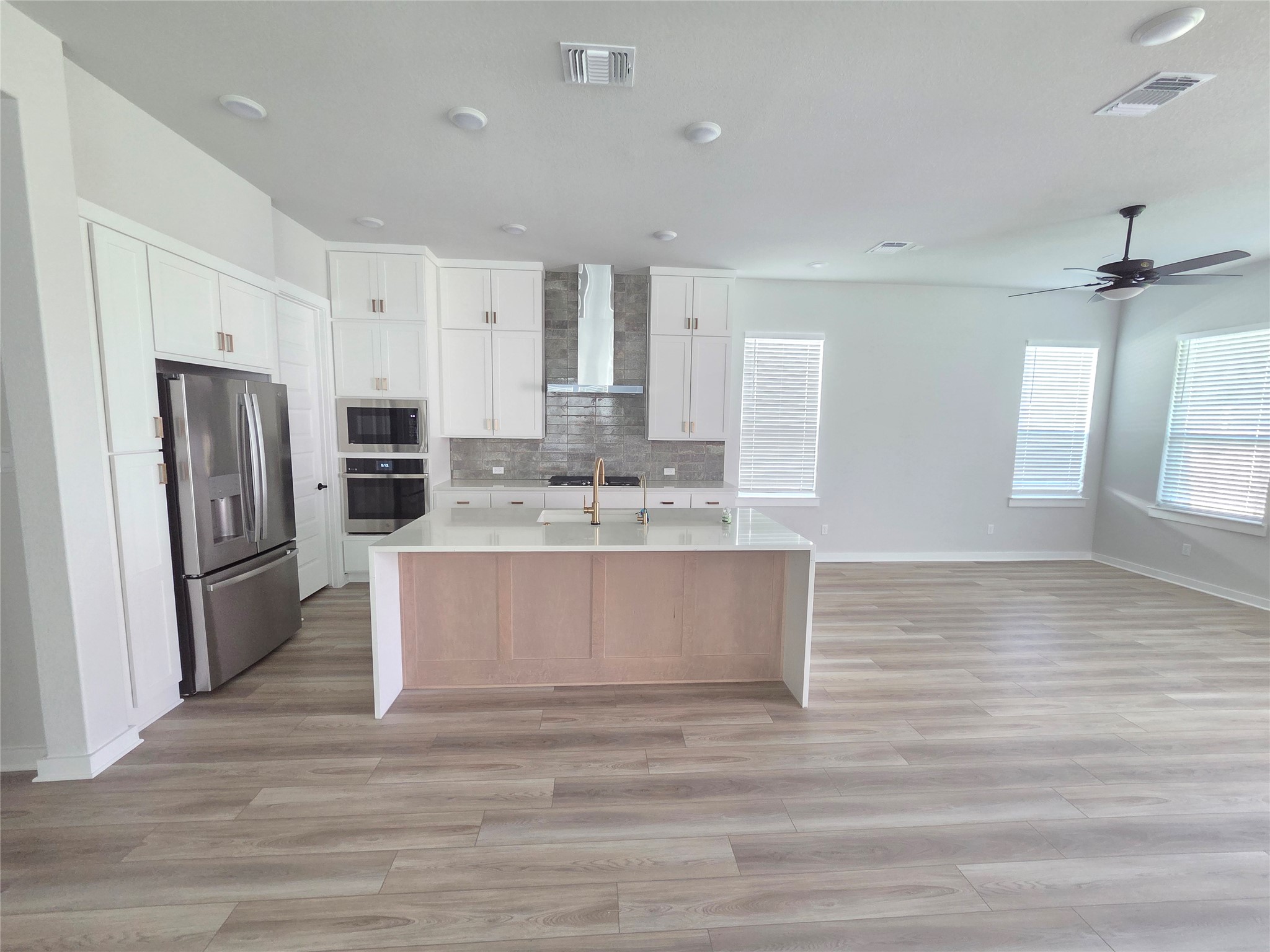 332 Marisol Bend Georgetown, TX 78626 - Photo 7 of 31 a large white kitchen with a refrigerator a stove a sink white cabinets and wooden floor