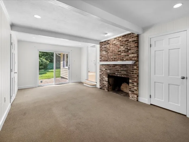 an empty room with windows and fireplace