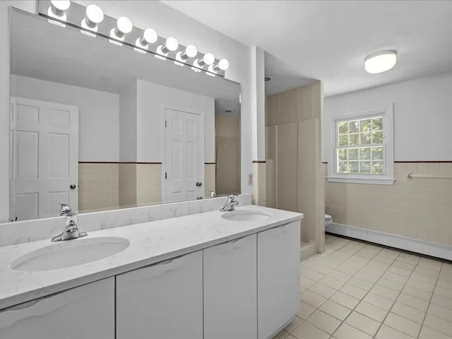 a bathroom with a sink double vanity granite and a mirror