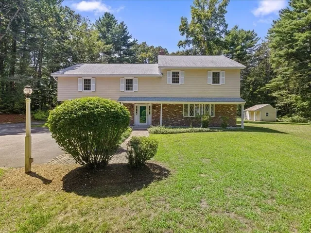a view of a house with backyard and sitting area