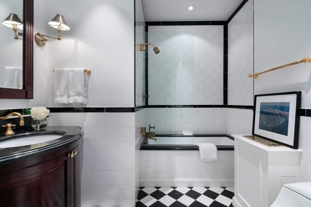 781 5th Avenue, Unit 505 Manhattan, NY 10022 - Photo 7 of 14 a bathroom with a sink a mirror and shower