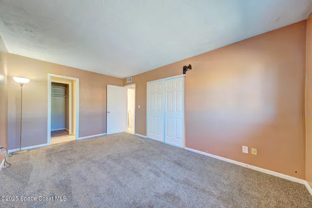 a view of a big room with closet and windows
