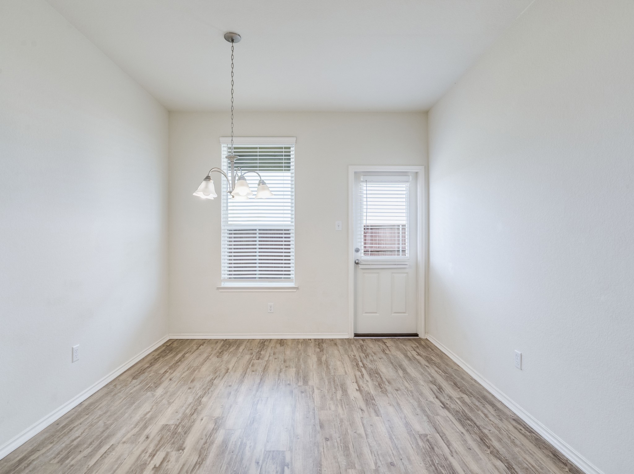 790 Pepperbark Loop Buda, TX 78610 - Photo 7 of 22 A versatile open space with wood-look flooring and a functional entry door leading to the outdoors.