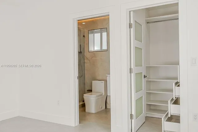 an empty room with a window and a ceiling fan