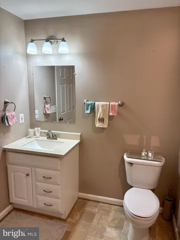 a bathroom with a granite countertop toilet sink and mirror