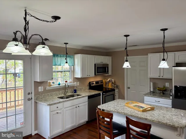 a kitchen with a stove a sink a dining table and chairs