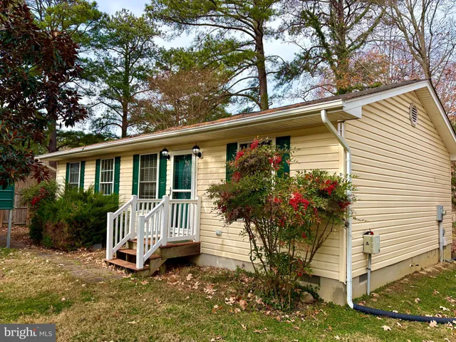 a wooden bench sitting in front of a house