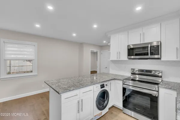 a kitchen with appliances a sink and cabinets