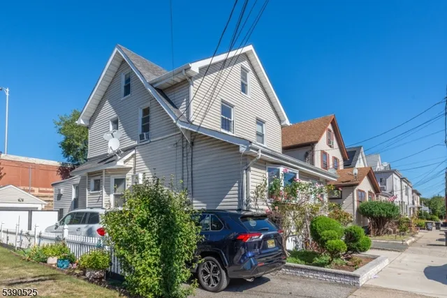 a view of a house with a yard and potted plants