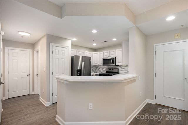 a kitchen with stainless steel appliances a refrigerator and a stove top oven