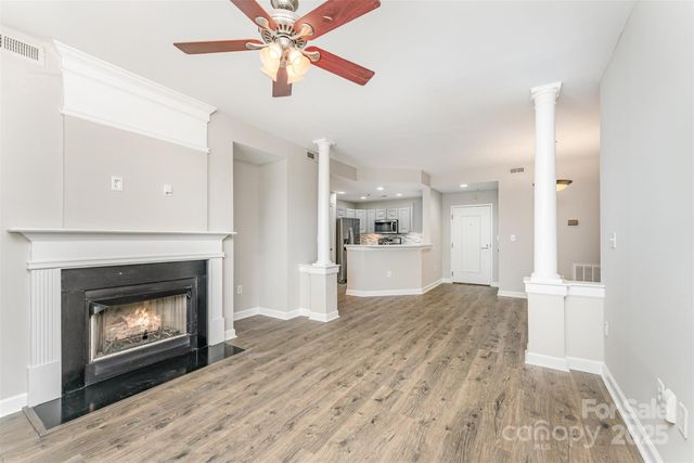 a view of a kitchen an empty room and fire place