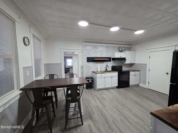 a kitchen with a table chairs refrigerator and cabinets