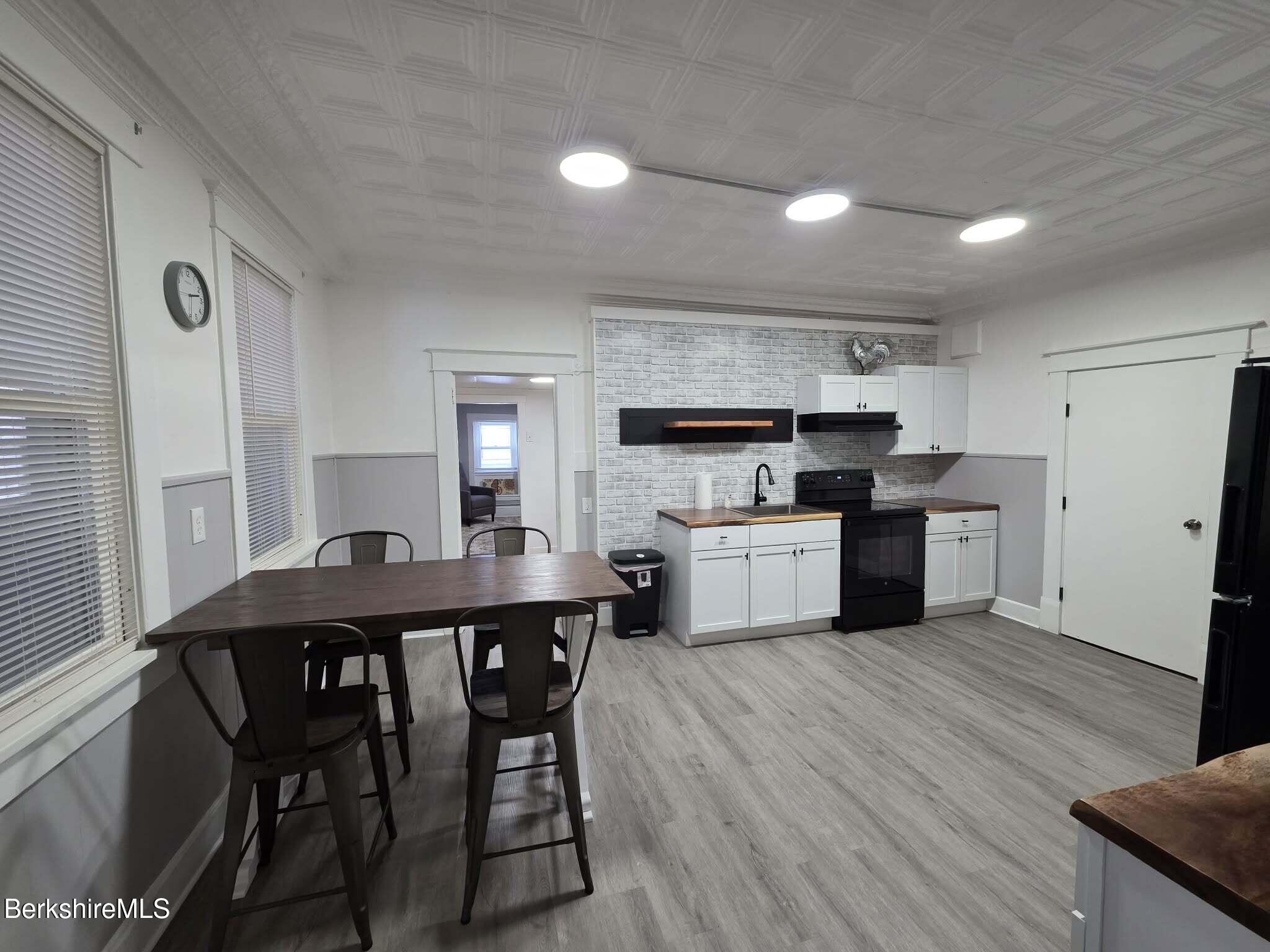 98 L Summer Street Adams, MA 01220 - Photo 4 of 17 a kitchen with a table chairs refrigerator and cabinets