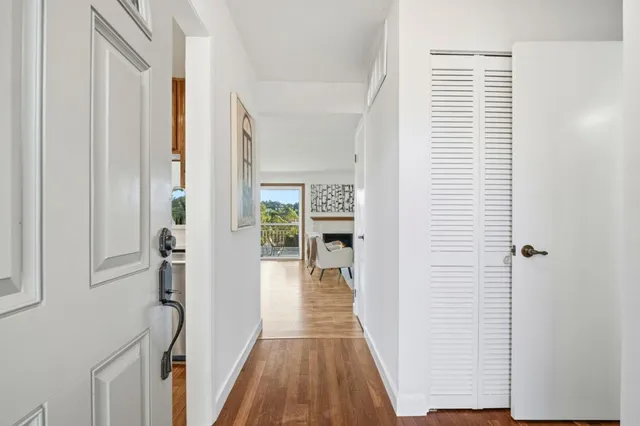 a kitchen with stainless steel appliances granite countertop a stove top oven a sink dishwasher a dining table and chairs with wooden floor