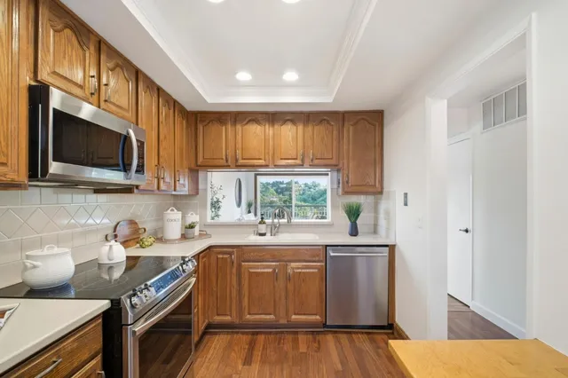 a kitchen with stainless steel appliances a stove microwave and refrigerator