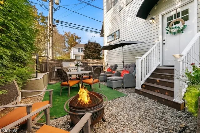 a view of a chair and tables in backyard of the house
