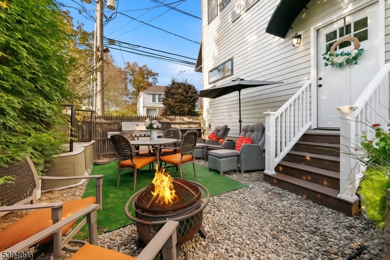 a view of a chair and tables in backyard of the house
