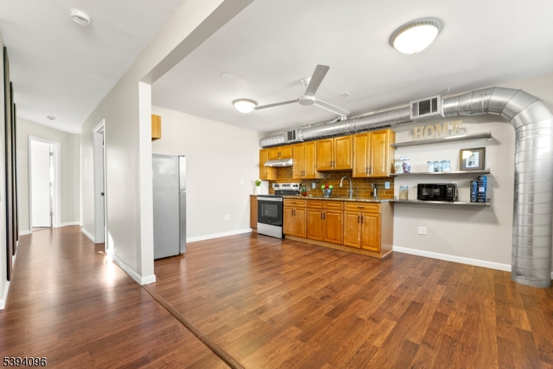 482 Springfield Avenue, Unit 2 Berkeley Heights, NJ 07922 - Photo 5 of 20 a kitchen with stainless steel appliances kitchen island granite countertop a refrigerator and stove top oven