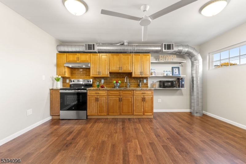 482 Springfield Avenue, Unit 2 Berkeley Heights, NJ 07922 - Photo 6 of 20 a kitchen with stainless steel appliances a stove top oven and a refrigerator