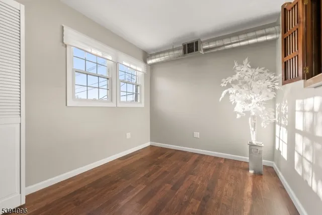 a view of a room with wooden floor and a window