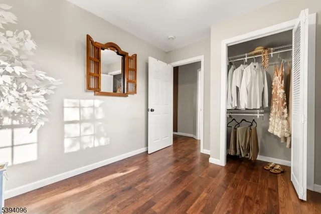 a view of a hallway with wooden floor and windows