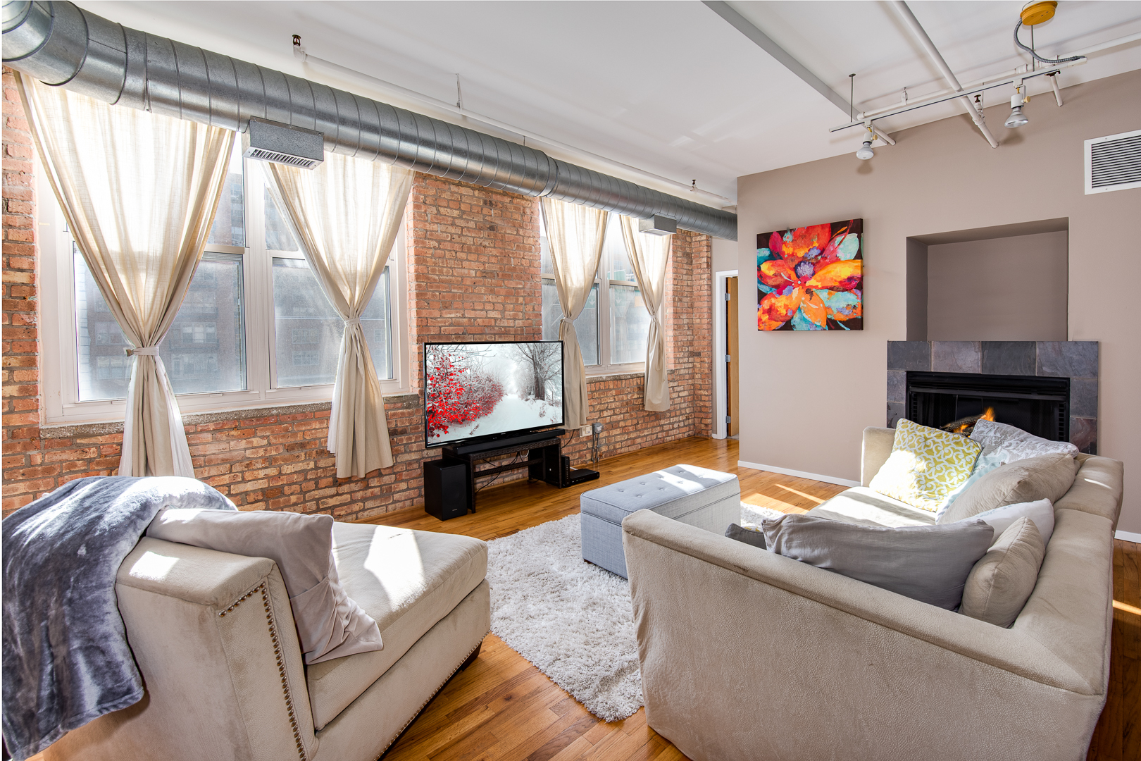 420 South Clinton Street, Unit 306A Chicago, IL 60607 - Photo 7 of 18 a living room with furniture a flat screen tv and a floor to ceiling window