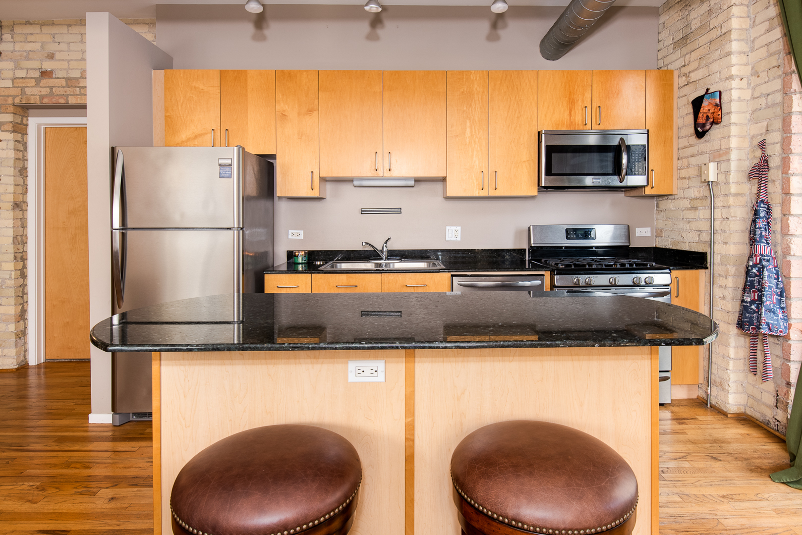 420 South Clinton Street, Unit 306A Chicago, IL 60607 - Photo 9 of 18 a kitchen with stainless steel appliances granite countertop a refrigerator a stove a sink and a microwave