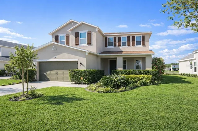 a front view of a house with a yard and garage